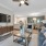 Living room with ceiling fan and light adjacent to dining area in unit at Heron Lake